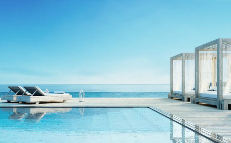 Terrasse mit Liegestühlen und Pool mit Blick aufs Meer